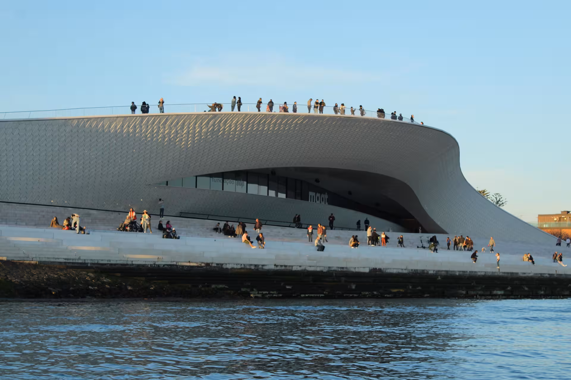 MAAT museum waterfront seen from a Lisbon sunset speedboat tour on the Tagus River at golden hour