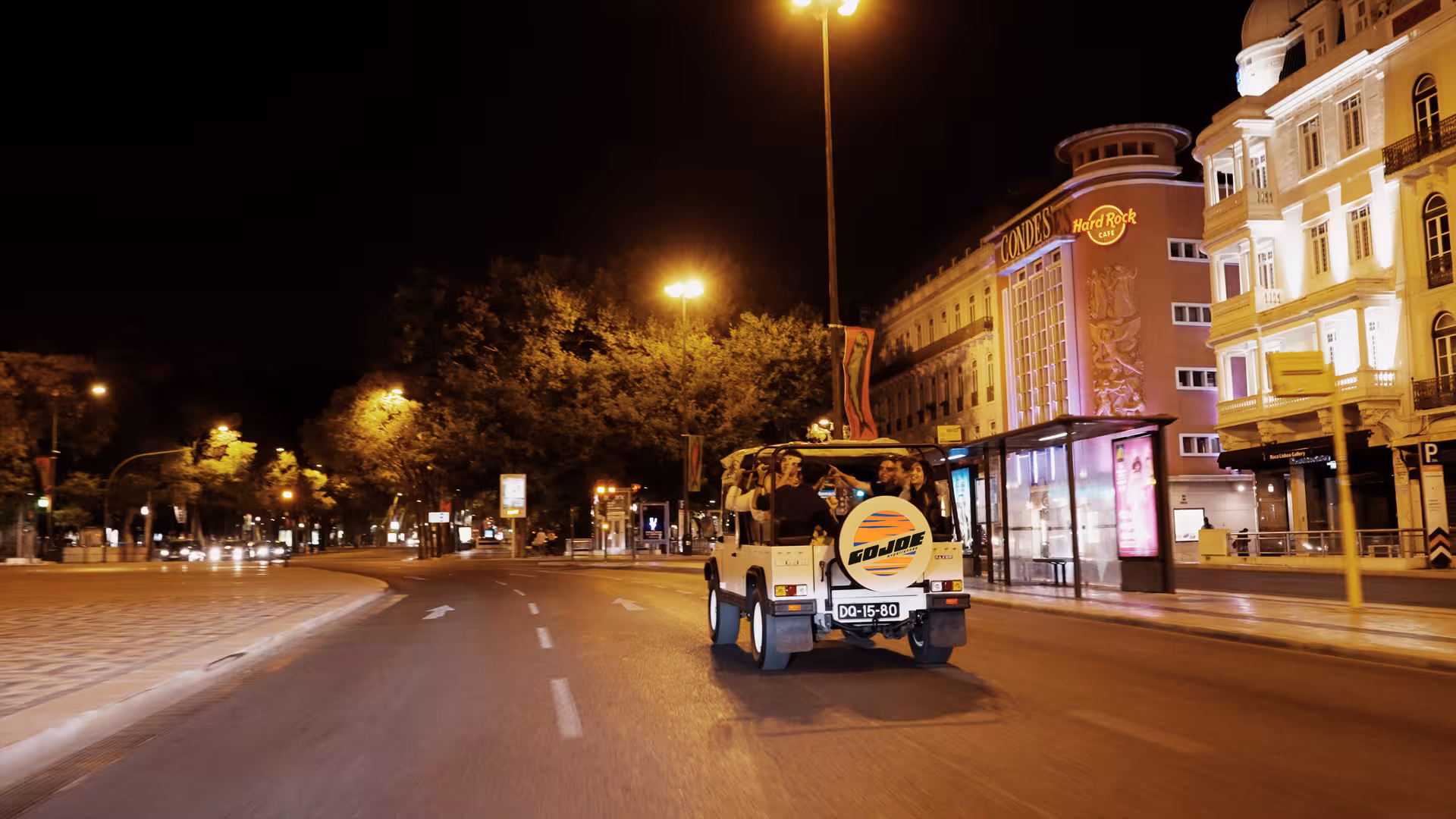 Vintage jeep cruising Lisbon at night near Avenida da Liberdade, sunset tour with food, drinks and views