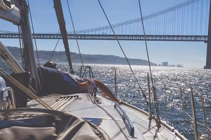Relaxing on a sailboat on the Tagus River under 25 de Abril Bridge, Lisbon 2h small group cruise with drink