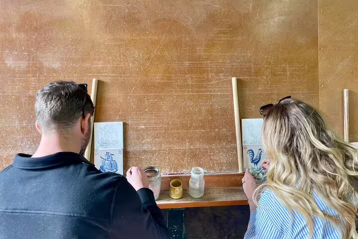 Participants enjoy a private tile painting workshop, part of a wine tasting and Sesimbra tour, enhancing their creative skills.