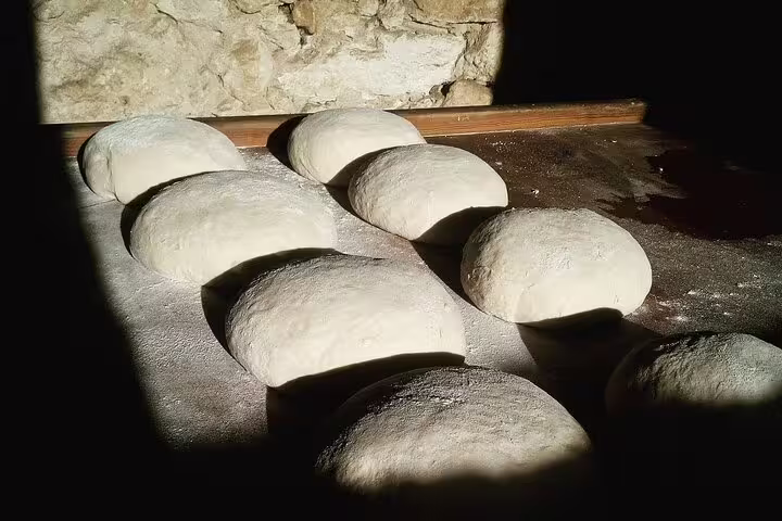 Freshly prepared dough resting on a wooden surface in a traditional Lisbon bakery, highlighting local culinary artistry.