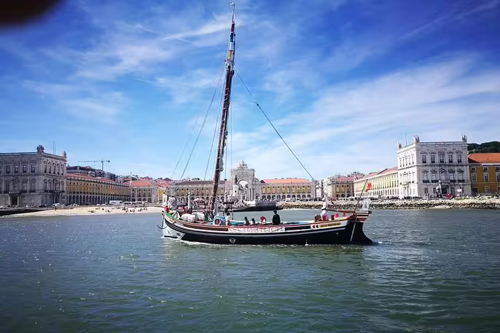 Classic Lisbon boat sailing near historic buildings, offering a picturesque guided sightseeing cruise experience in Portugal.
