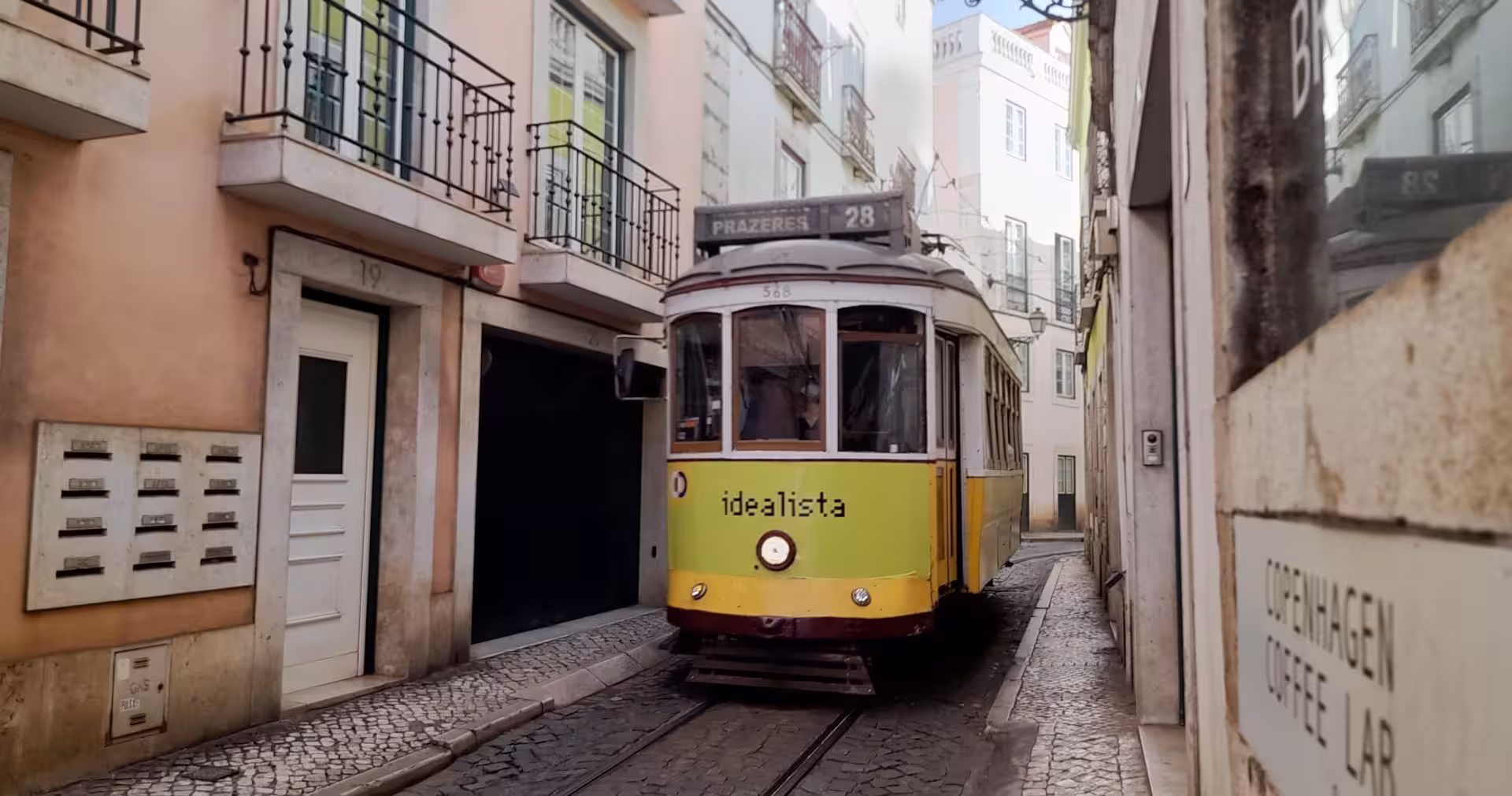 Lisbon Tram 28 riding through Alfama streets, classic experience on a Lisbon & Sintra full-day historical tour