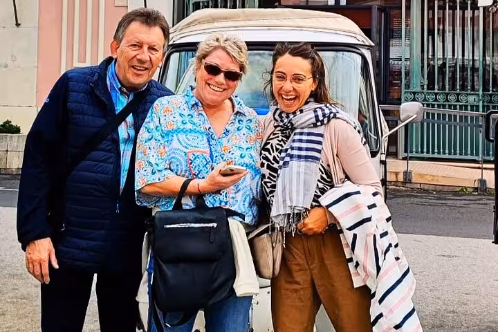 Smiling group after a Lisbon tuk tuk tour, posing by the vehicle before exploring the Old Town sights