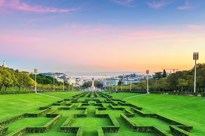 Sunset view of Lisbon's Eduardo VII Park, showcasing lush greenery and cityscape, ideal for a private TukTuk tour experience.
