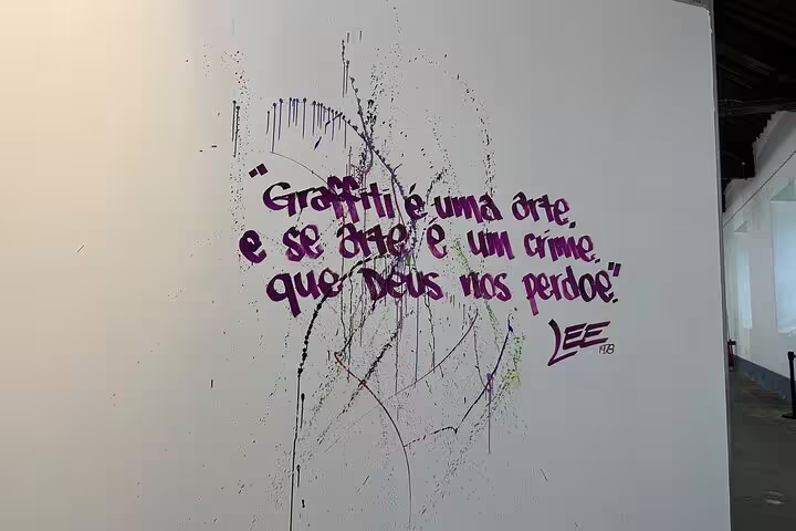 Graffiti wall in Lisbon with purple text reflecting on art and crime, adding depth to the urban art tour experience.