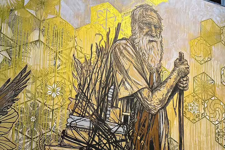 Striking Lisbon mural of an elderly figure with a staff, highlighting the city's rich urban art and storytelling heritage.