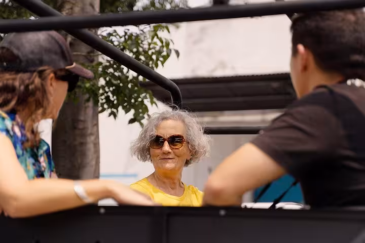 Guests riding a vintage Jeep in Lisbon during a daily sightseeing tour with food and drink stops