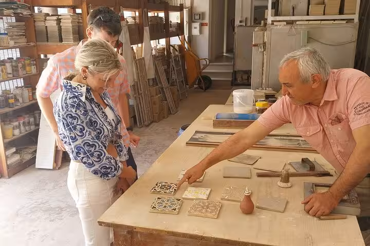 Guests learning Portuguese tile craft during Lisbon wine tour, cultural stop with premium wine and food tastings