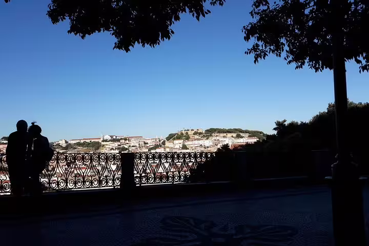 Scenic view of Lisbon's historic skyline from a shaded viewpoint, perfect for the World Heritage Deluxe Tour experience.