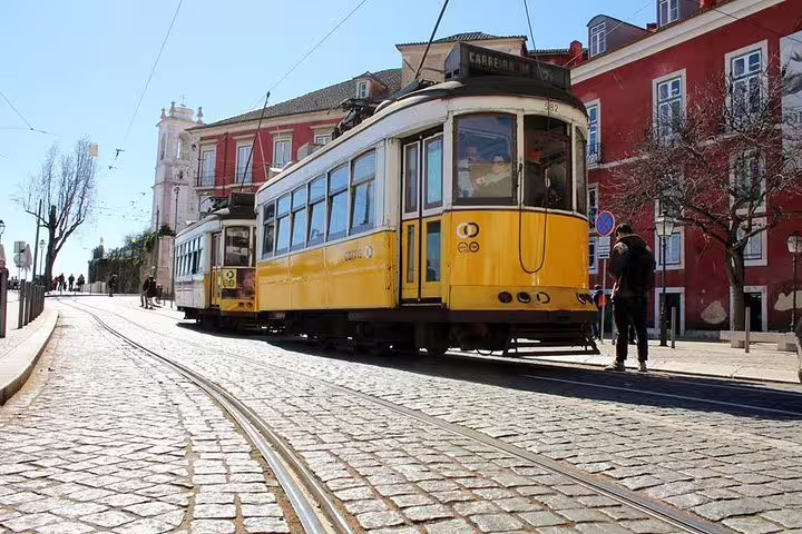 Iconic yellow tram on a sunlit cobblestone street in Lisbon, perfect for a private half-day tour with custom stops.