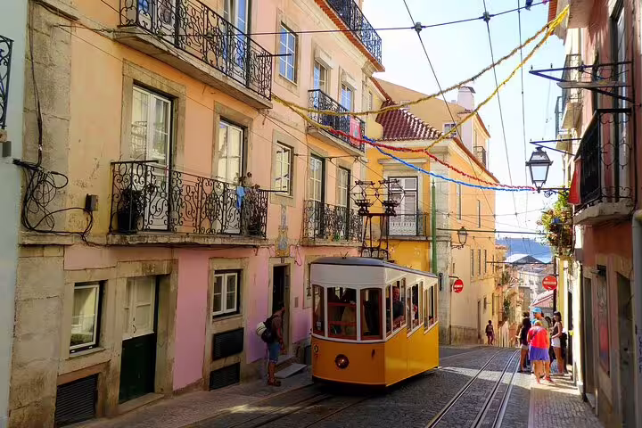 Charming yellow tram navigates colorful streets in Lisbon, perfect for exploring on a vegan-friendly walking tour.