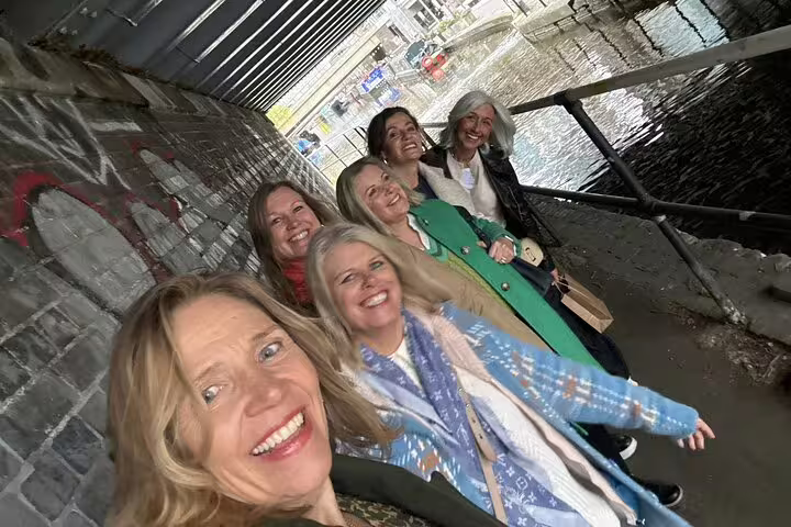 Group of women smiling for selfie under brick bridge tunnel near Little Venice London canal