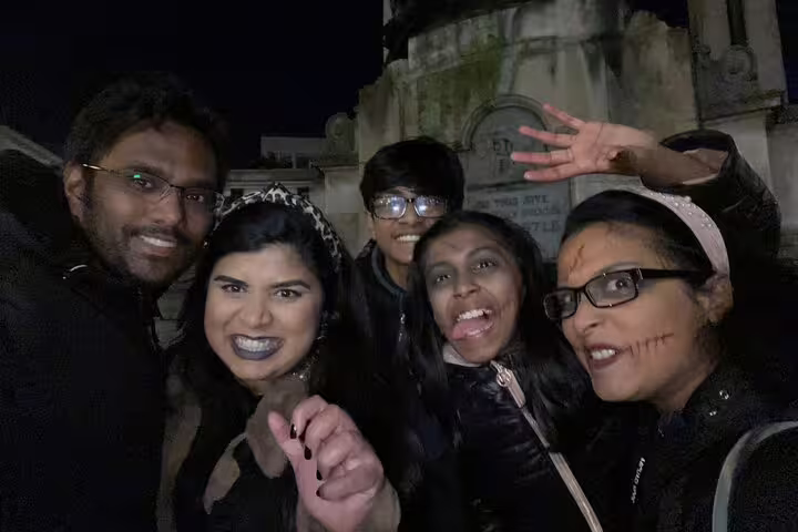 Group of five friends in Halloween makeup posing at night near cemetery during Liverpool ghost tour
