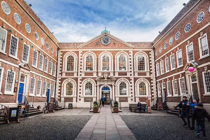 Historic red brick Georgian courtyard building in Liverpool with clock tower and cobblestone square