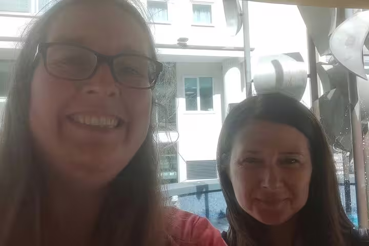 Two smiling women on Liverpool self-guided walking tour with city buildings in background