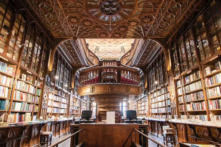 Explore the stunning interior of Livraria Lello in Porto during a full-day private tuk tuk tour, showcasing its intricate woodwork and historic charm.