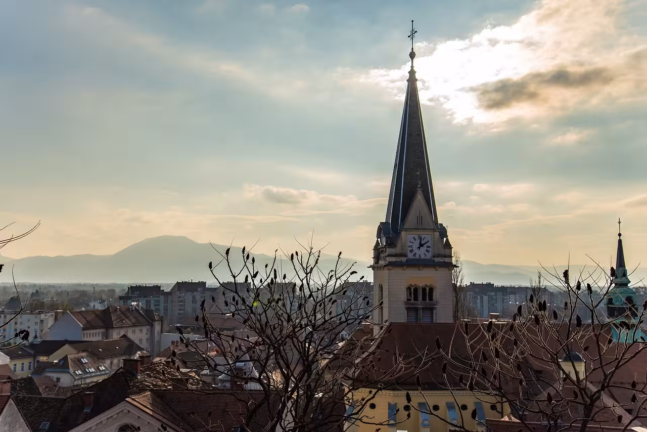 Ljubljana skyline with St Nicholas Cathedral clock tower at sunset, scenic stop on Ljubljana highlights tour