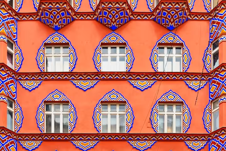 Ornate colorful facade of a Ljubljana building with blue and orange geometric window decorations