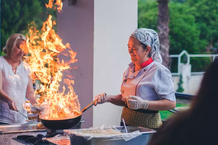 Local chef flambéing a pan during a Marseille cooking class, hands-on Provençal cuisine workshop experience
