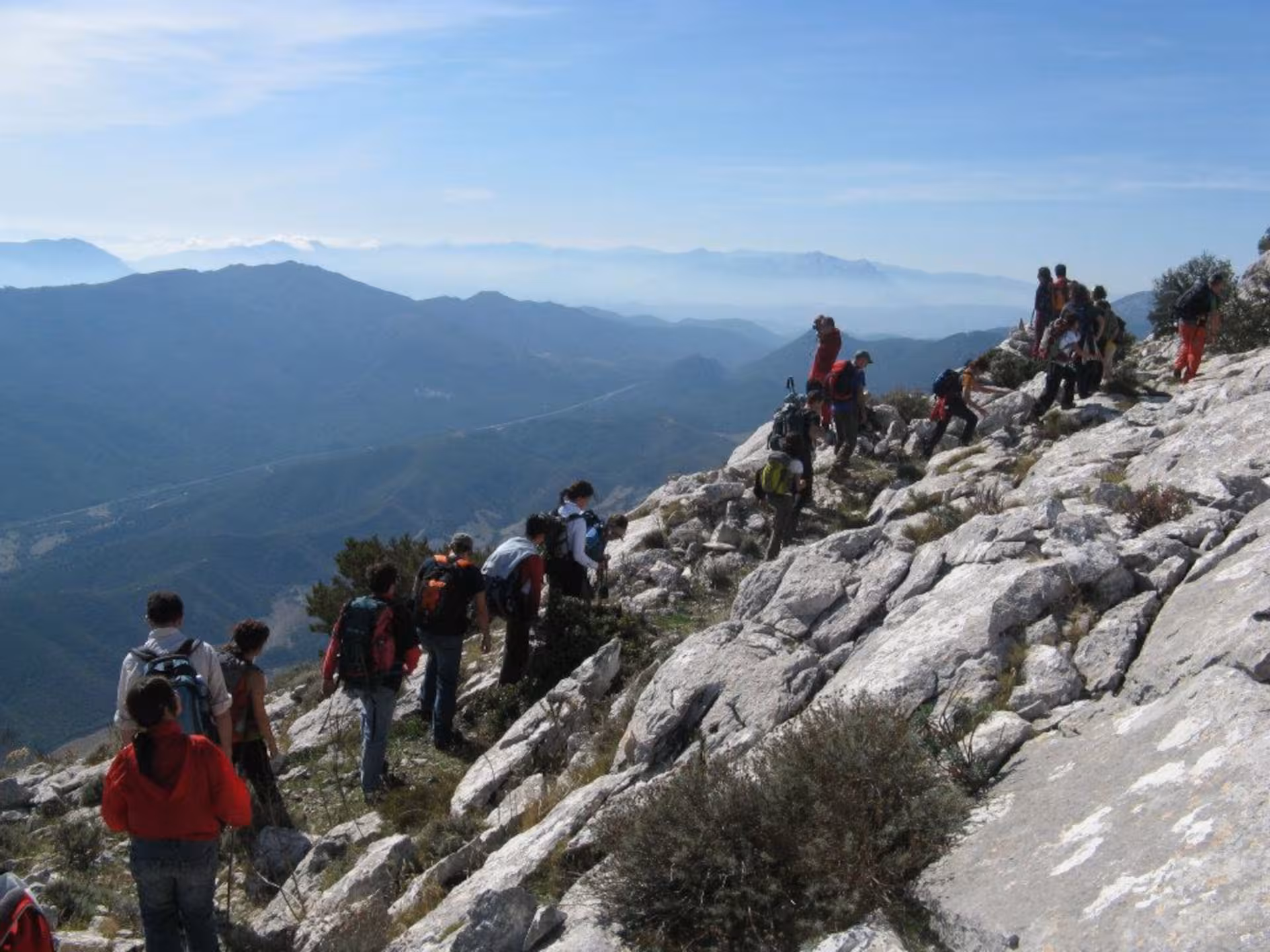 Group of hikers exploring Montalbo's rocky paths with stunning mountain views, showcasing Lodè's trekking tours.