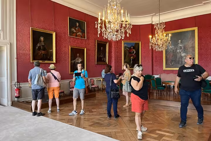 Guided visit inside a Loire Valley château salon with chandeliers and portraits, included in wine tasting tour with lunch
