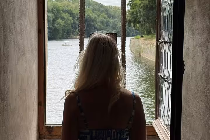 Traveler gazes over the Loire River from a castle window during a Loire Valley wine tasting and chateau tour