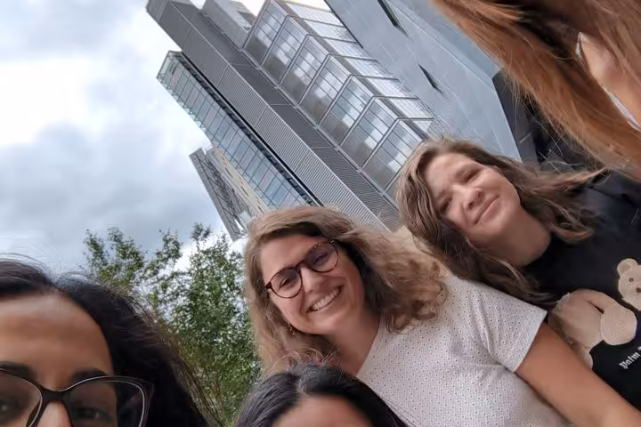 Group of smiling women on a self-guided walking tour near modern London skyscrapers