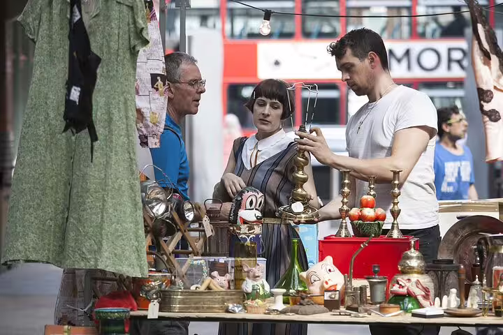 Visitors explore vibrant stalls filled with eclectic antiques and curiosities at a bustling London market during a private tour.