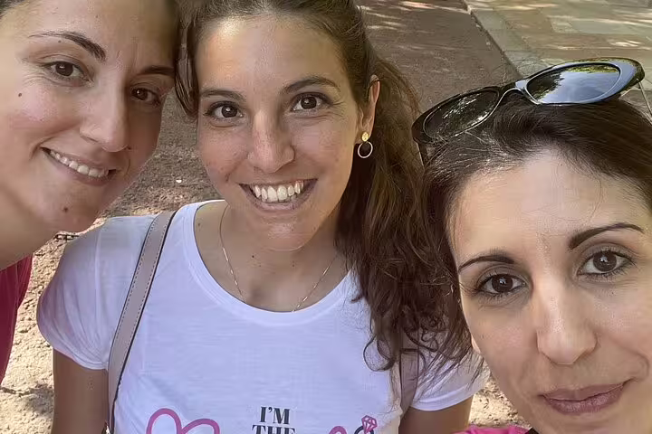Three smiling women taking a selfie outdoors during a London walking tour