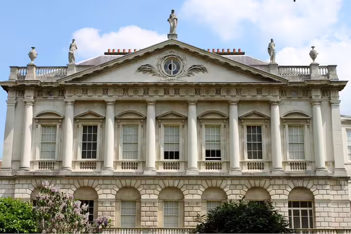 Neoclassical white stone building with columns and statues, part of London's royal architecture