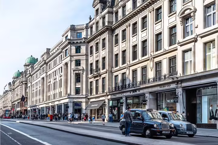 Regent Street London with black taxi cabs and grand Georgian buildings lining a busy shopping street