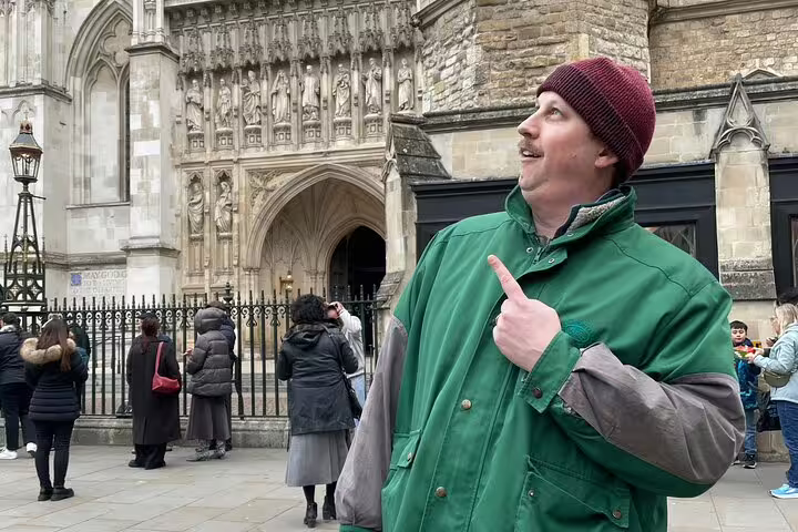 Tour guide pointing at Westminster Abbey entrance during London Royal Walking Tour escape game
