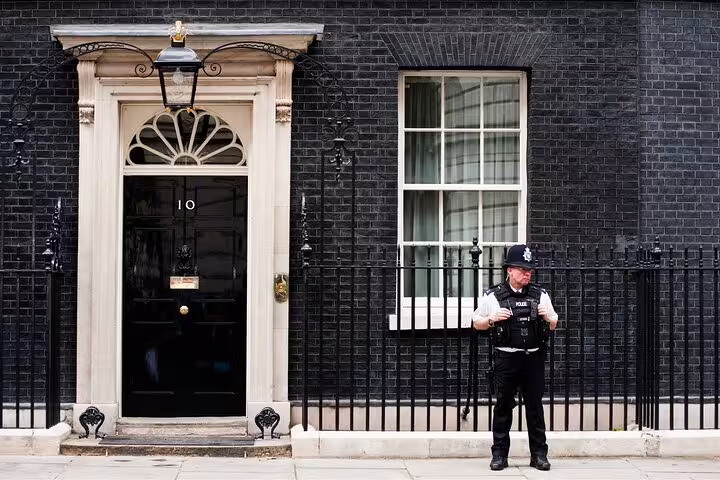 A police officer stands guard outside the iconic 10 Downing Street, a highlight of the London full-day private tour.