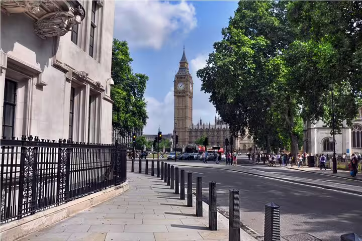 View of Big Ben and Houses of Parliament from a London street with iron railings and bollards