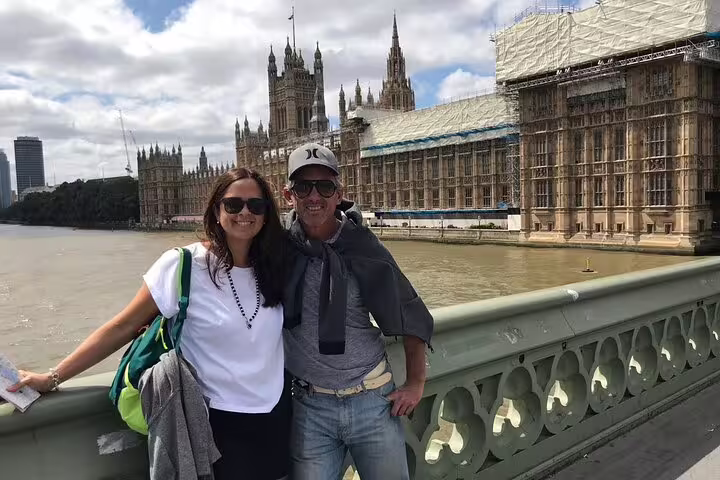 Tourists enjoying a sunny day on Westminster Bridge with the iconic Houses of Parliament in the background, London private tour.
