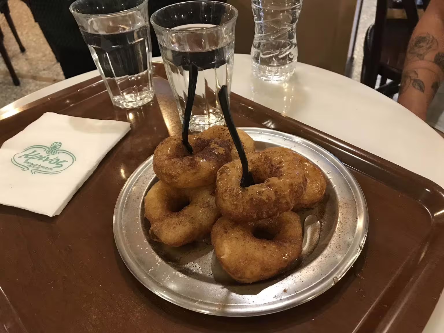 Loukoumades honey donuts served with water at a café stop on a gourmet food walking tour in Athens