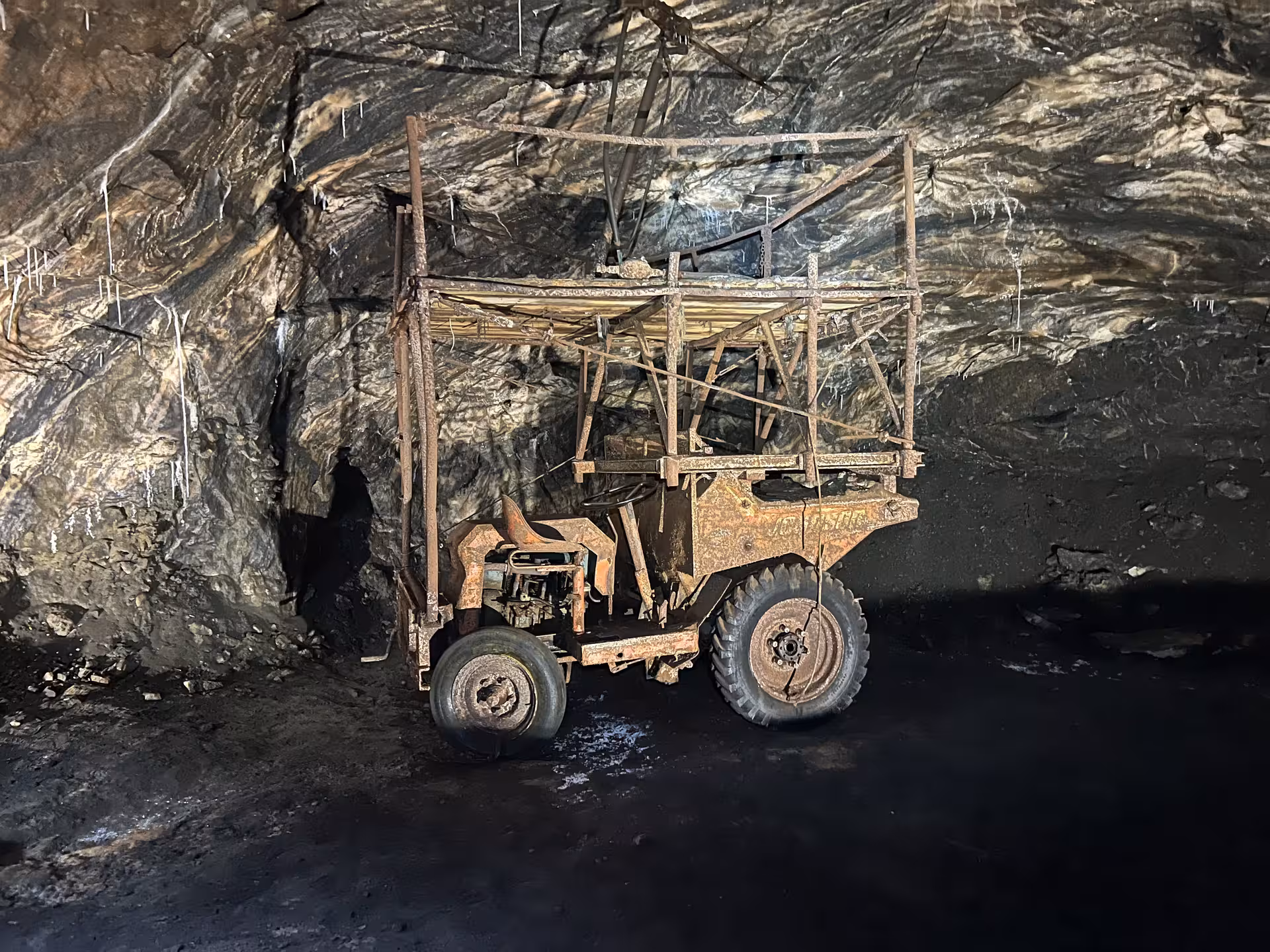 Old mining equipment in the Loulé rocksalt mine, featuring textured walls illuminated by soft lighting.