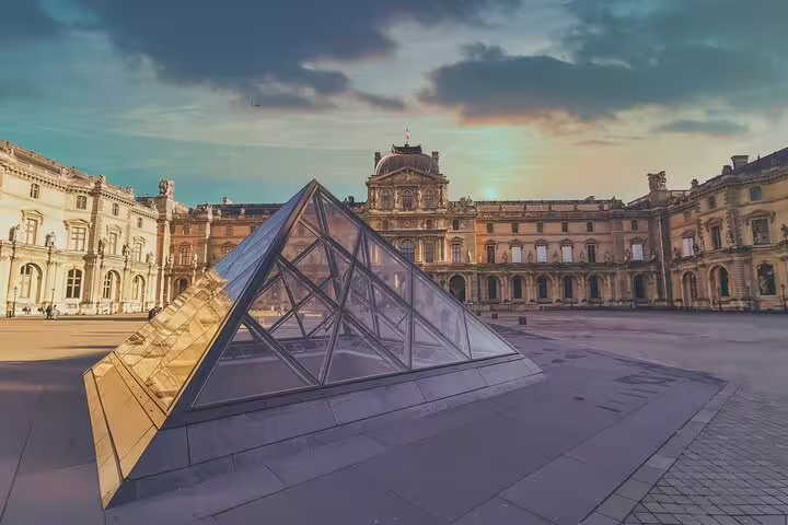 Glass pyramid at the Louvre Museum courtyard in Paris at sunset