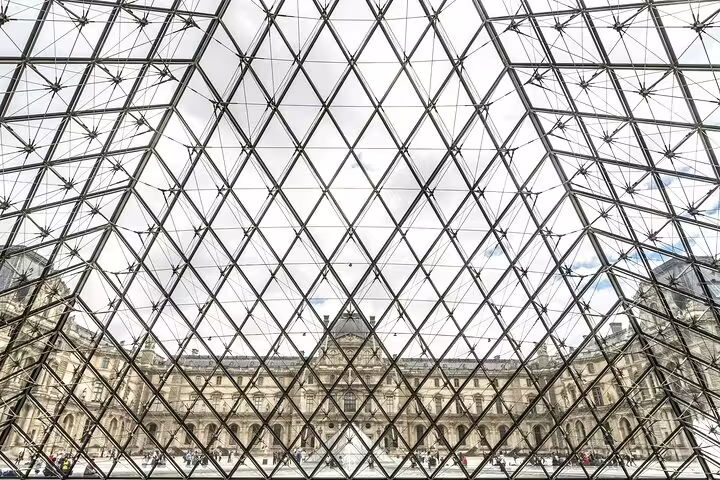 View of the Louvre Palace through the iconic glass pyramid, showcasing the architectural marvels of the museum.