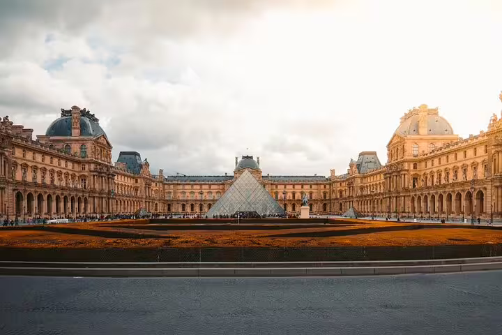 Louvre Museum courtyard with iconic glass pyramid and classical French architecture in Paris