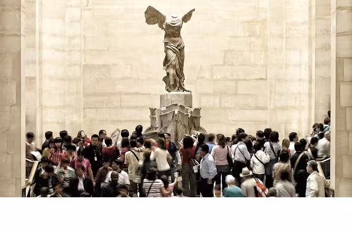 Crowds viewing the Winged Victory of Samothrace on a Louvre Museum tour in Paris with private guide option