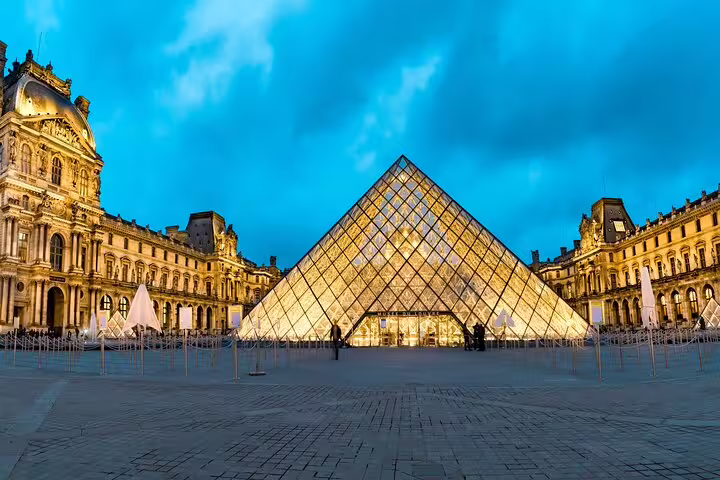 Illuminated Louvre Pyramid at dusk, showcasing Paris's hidden gems and undiscovered quarters on an exclusive city tour.
