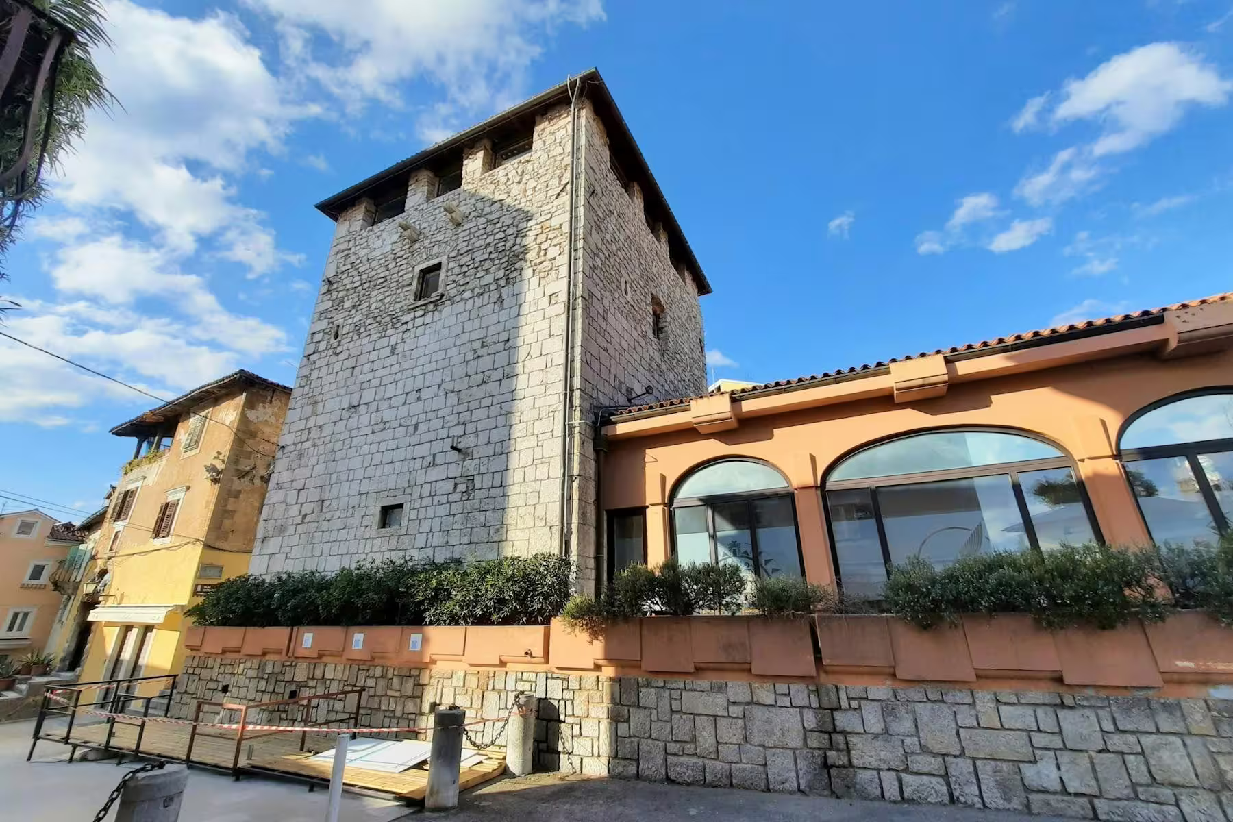 Historic stone tower and waterfront buildings in Lovran old town, stop on Kvarner Bay local food tour