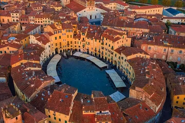 Aerial view of the historic Piazza dell'Anfiteatro in Lucca, encircled by charming Tuscan buildings.
