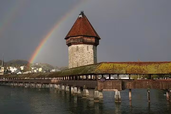 Scenic view of Lucerne's iconic Chapel Bridge with vibrant rainbow, perfect for a private classic walking tour experience.