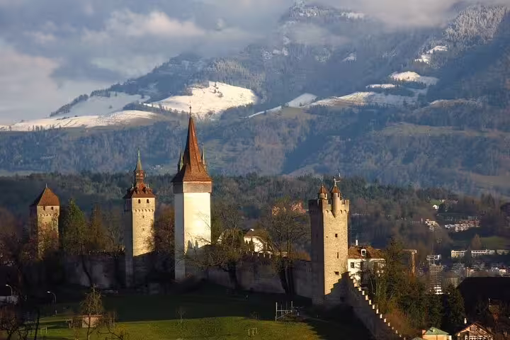 Medieval Lucerne city walls and towers with snow-capped Swiss Alps mountains in background