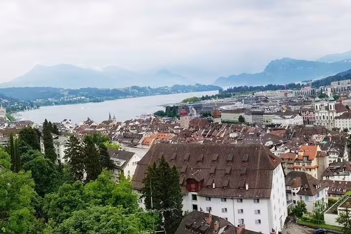 Aerial view of Lucerne old town with red rooftops, Lake Lucerne, and misty Alps in background