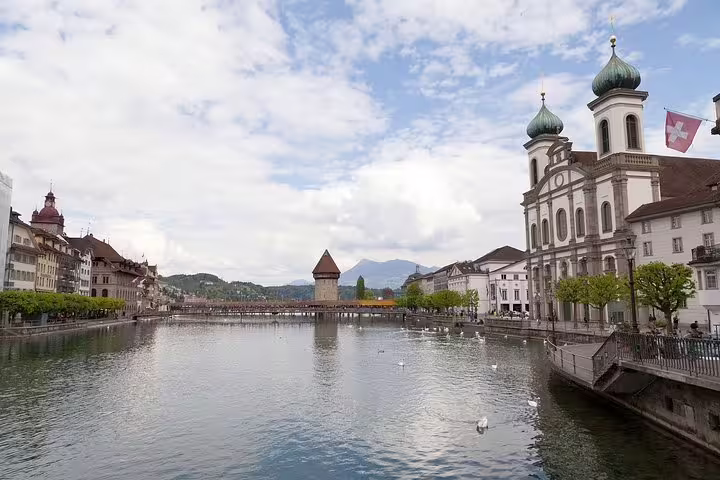 Stunning view of Lucerne's Reuss River, historic architecture, and swans on a private guided tour.