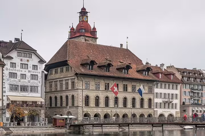 Historic Lucerne Town Hall with Swiss flag on the Reuss River waterfront, Switzerland